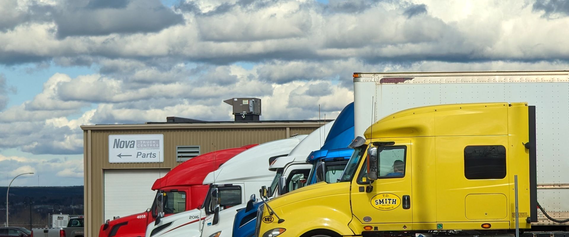 A row of tractor cabs at a truck yard. What is a bill of lading? The paper every one of these moves under.