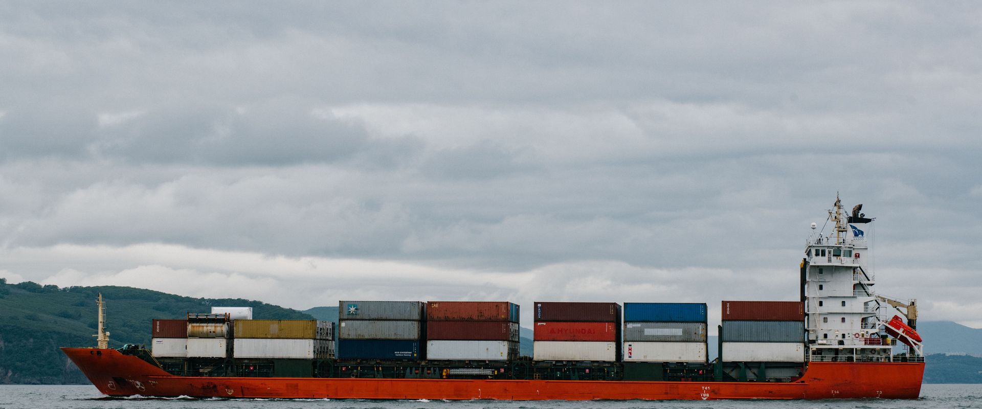 Container ship under way with stacked boxes: what to do after your container clears customs starts before it docks