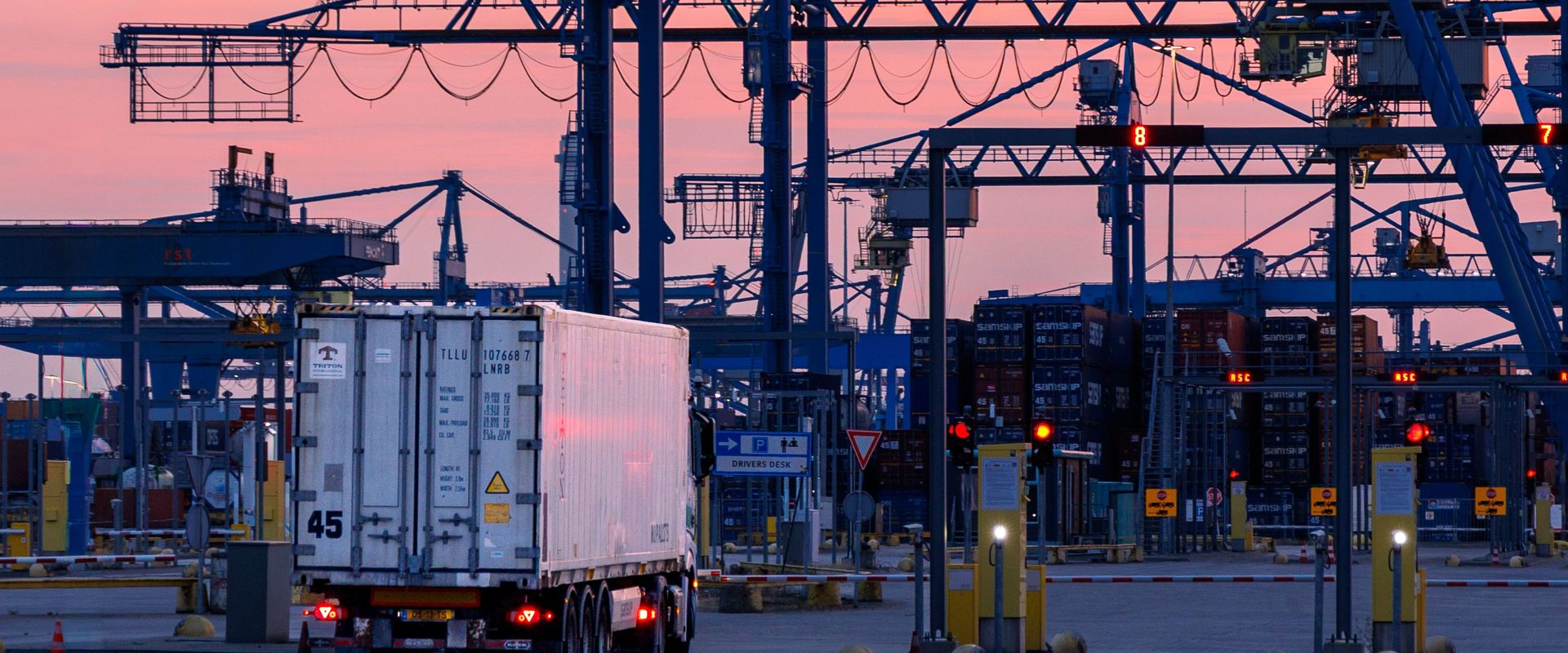 Container terminal cranes at dusk, where domestic freight for importers begins